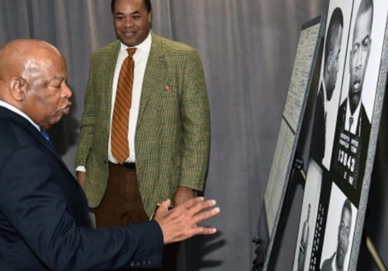 A man explaining information on a display board to another man.