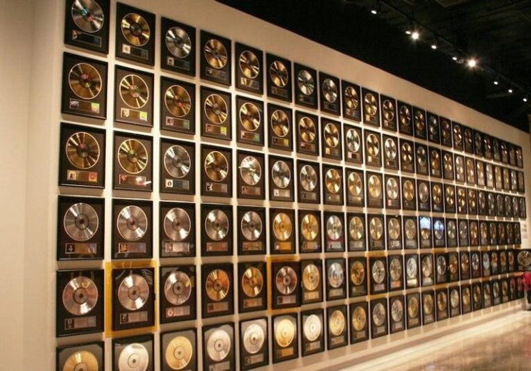 Wall displaying numerous gold and platinum music awards.