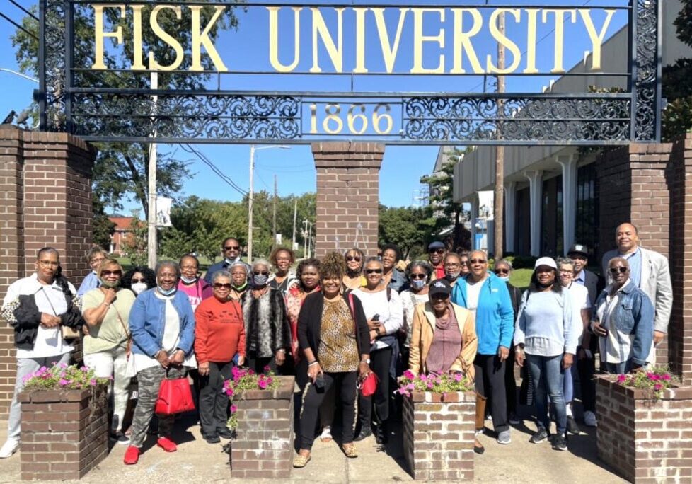Group photo of diverse people at Fisk University entrance.