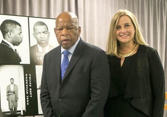 Two professionals standing in front of a historical photo.