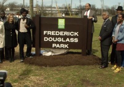 People unveiling a sign for Frederick Douglass Park.