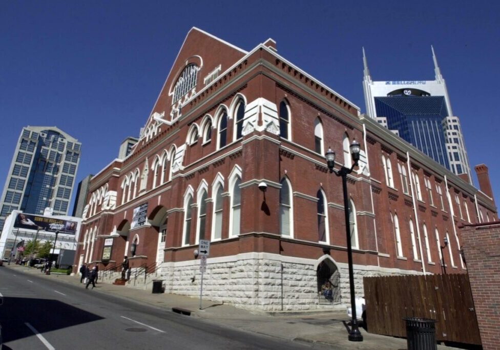 Historic red-brick building with white stone accents under a clear blue sky.